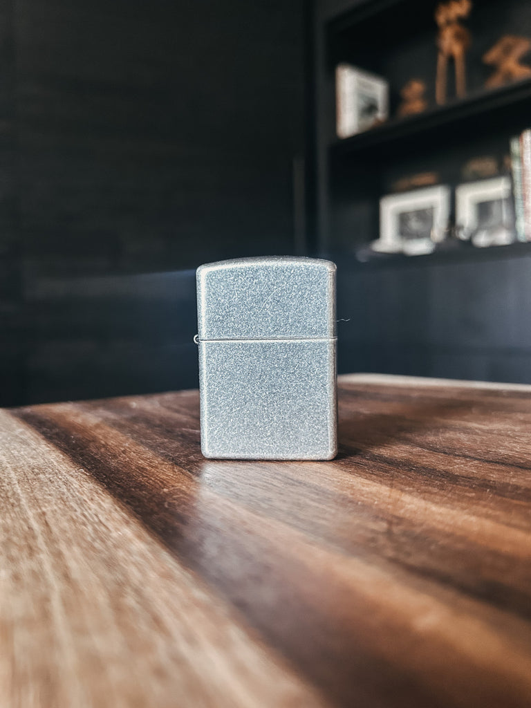 A Zippo lighter in the 'Armor Antique' finish, featuring a rugged, vintage-inspired design.