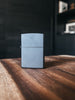 A Zippo lighter in a sleek matte black finish, showcasing its minimalist and modern design.