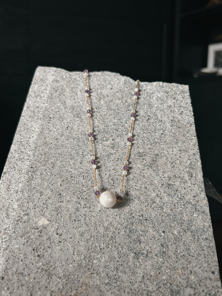 A gorgeous necklace made with moonstone, amethyst, and a large edison pearl. Handcrafted on the island of Kauai, Hawaii.