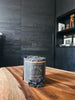 The Palo Santo candle by Piedalu featuring notes of orange, amber, mahogany bark, birch, olibanum, guaiac wood, and balsam cedar.