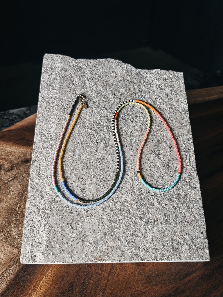 Long 30-inch Rangi necklace with Japanese glass beads and gold clasp, designed for layering or statement wear.