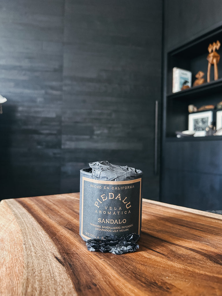 The Sandalo candle by Piedalu featuring notes of oak moss, sandalwood, patchouli, cedar wood, lily, and melon.