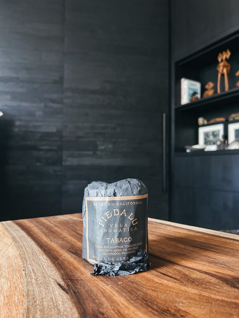 The Tabaco candle by Piedalu featuring notes of thyme, eucalyptus, tobacco leaf, hyacinth, moss, fir needle, cedar wood, and patchouli.
