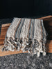 A tan and gray striped Turkish towel made of soft, lightweight cotton.