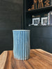 A tall ceramic tumbler with a ribbed texture and soft blue glaze.