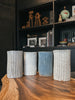 Four tall ceramic tumblers with ribbed texture and varied natural glazes.